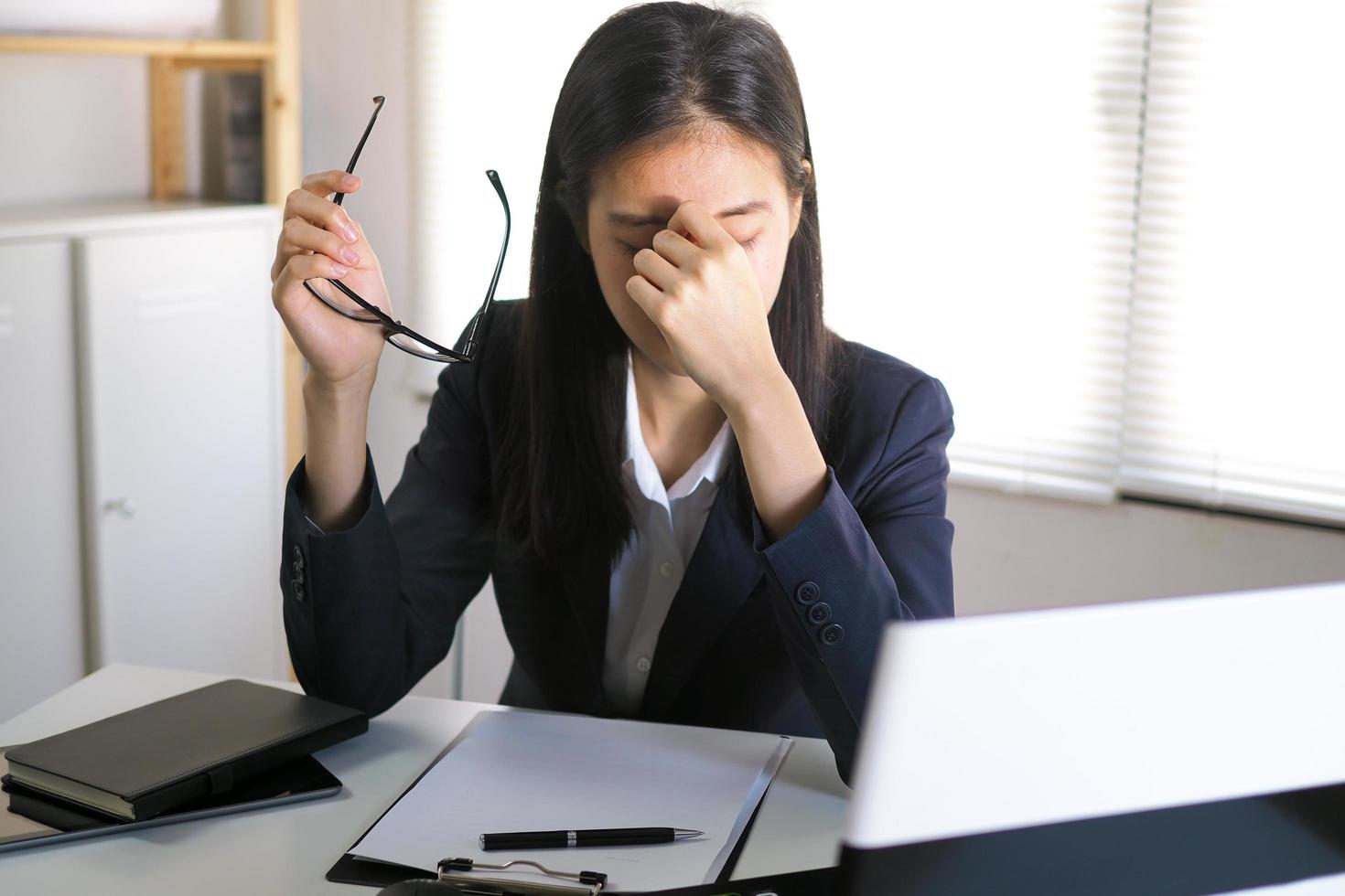 jong onderneemsters hebben migraine hoofdpijn terwijl werken in de kantoor. foto