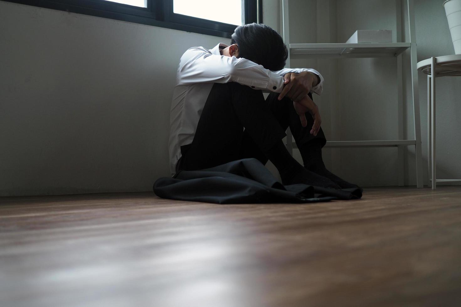 zakenlieden zijn gestrest, zittend binnen de kamer, verdrietig en teleurgesteld. besteden tijd alleen met druk Aan problemen foto