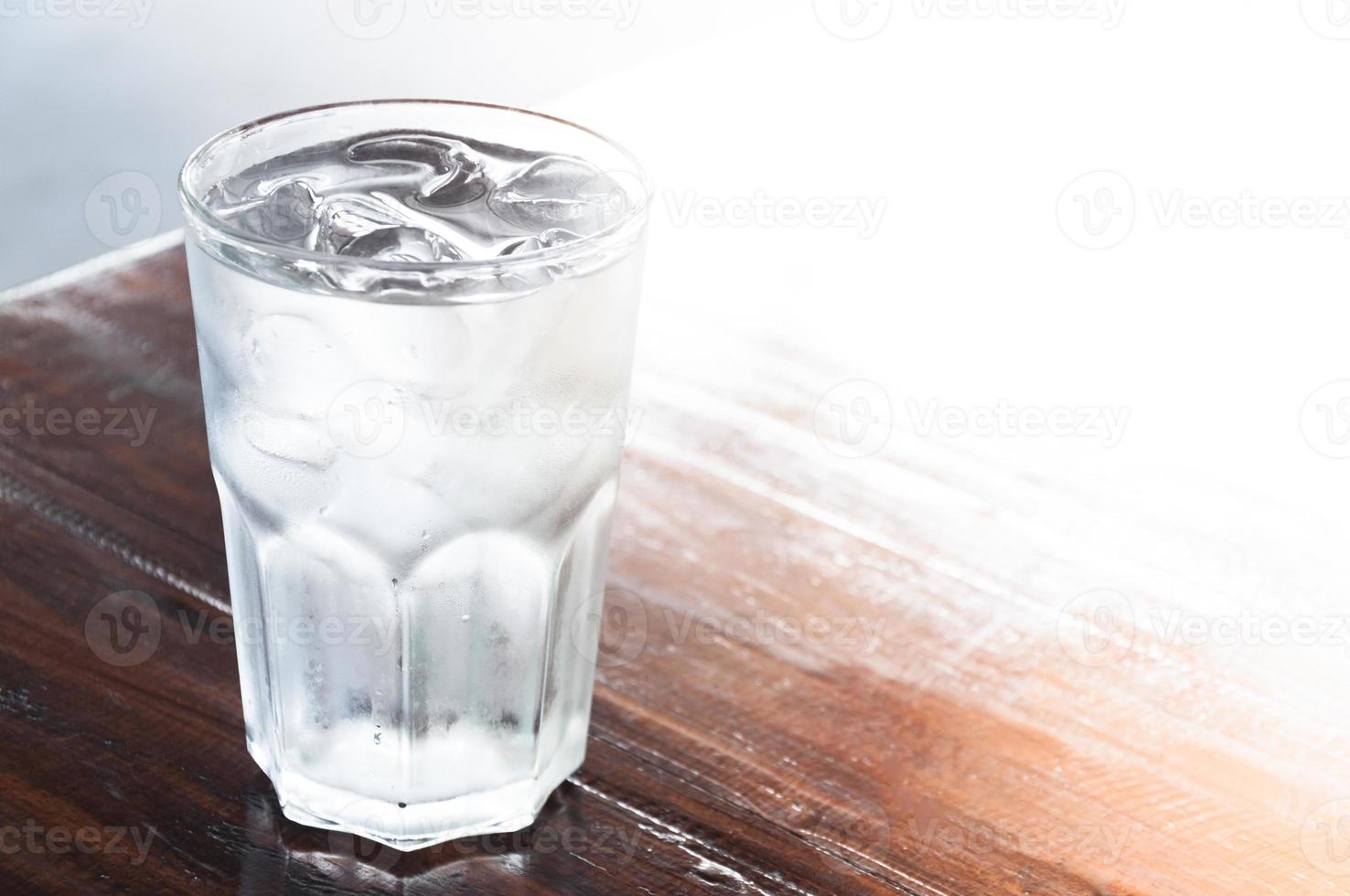 glas van water met ijs Aan houten tafel , schoon water, drinken water foto