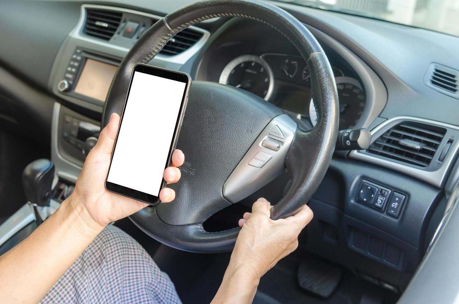 hand met een mobiele telefoon in de auto foto