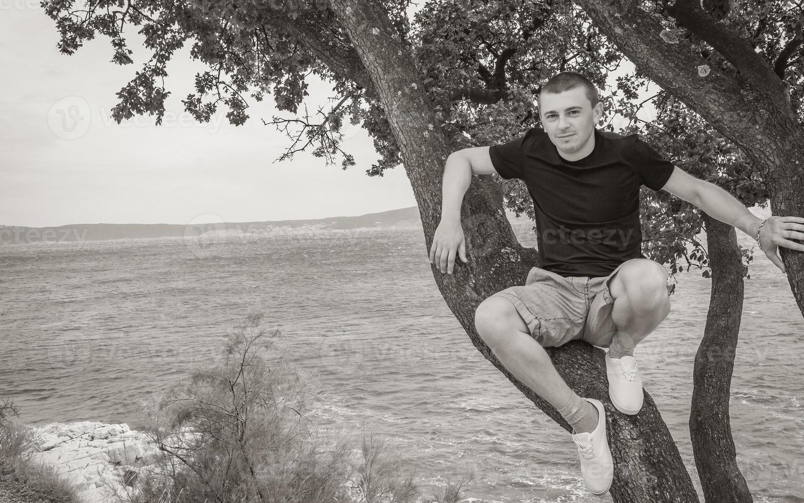 jong mannetje model- zittend Aan boom landschap nieuw vinodolski Kroatië. foto