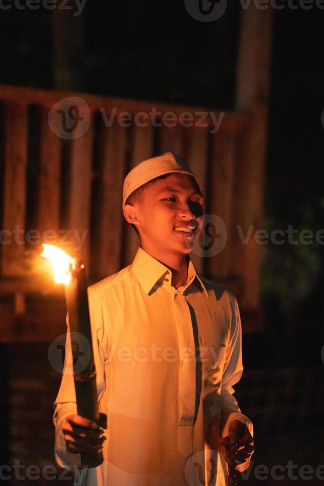 een moslim Mens Holding een brand fakkel Bij de camping in de dorp foto