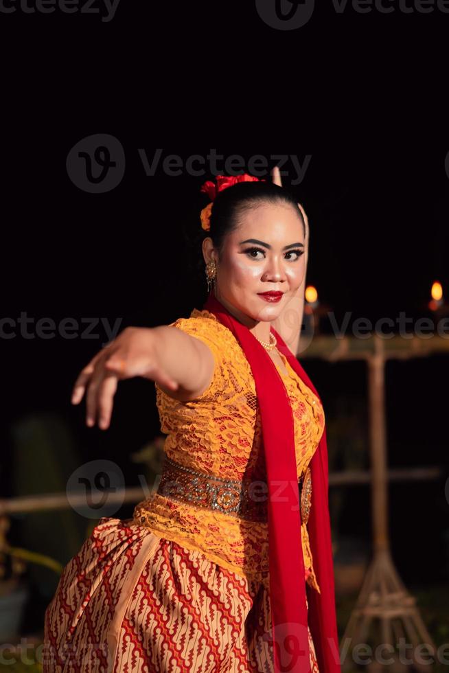 Sundanees vrouw met een exotisch gezicht vervelend een geel jurk en rood sjaal gedurende een dans tentoonstelling foto