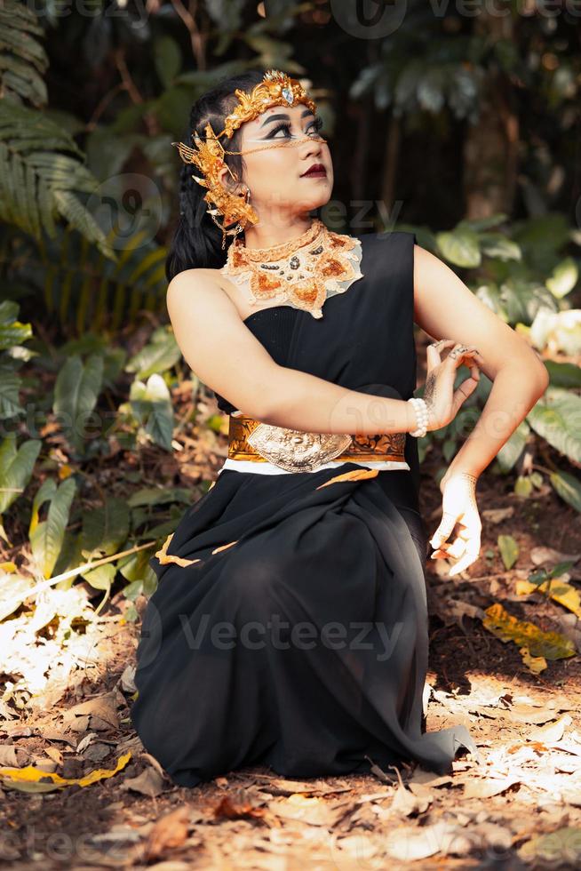 Indisch vrouw vervelend een zwart jurk met een gouden kroon en gouden ketting Aan haar lichaam foto