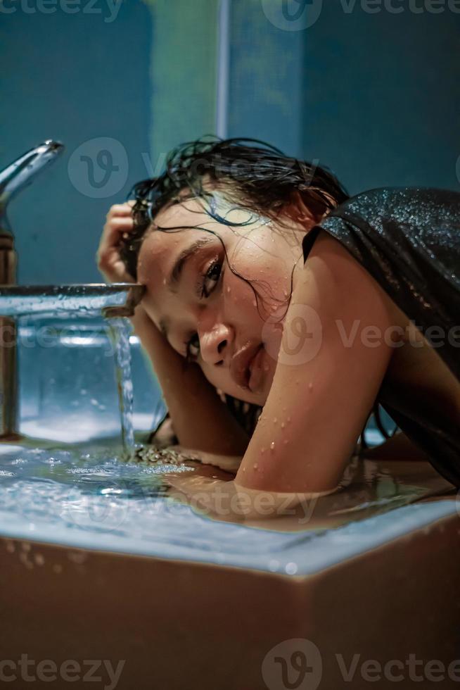 Indonesisch Dames wassen haar hand- in de wastafel terwijl hun haar- was nat foto