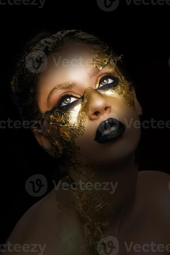 mode kunst gouden huid. model- meisje met feestelijk gouden glamoureus glimmend professioneel verzinnen. goud sieraden, bijouterie, accessoires. mooi gouden metalen lichaam, zwart lippen en huid. foto