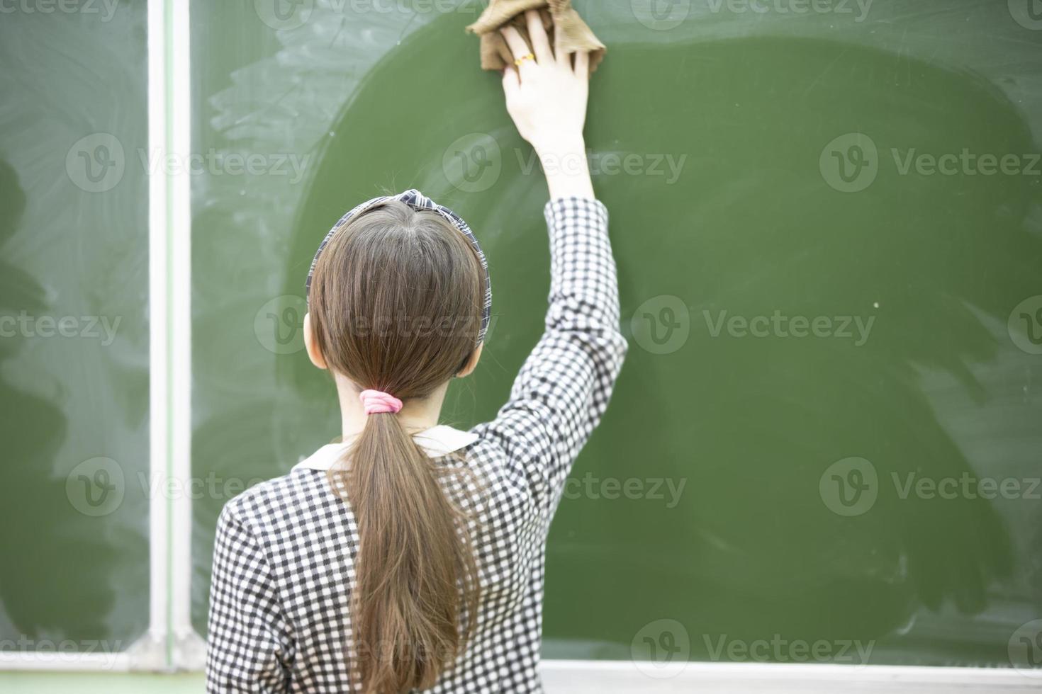 een midden- school- of junior hoog school- leerling doekjes de schoolbord. foto
