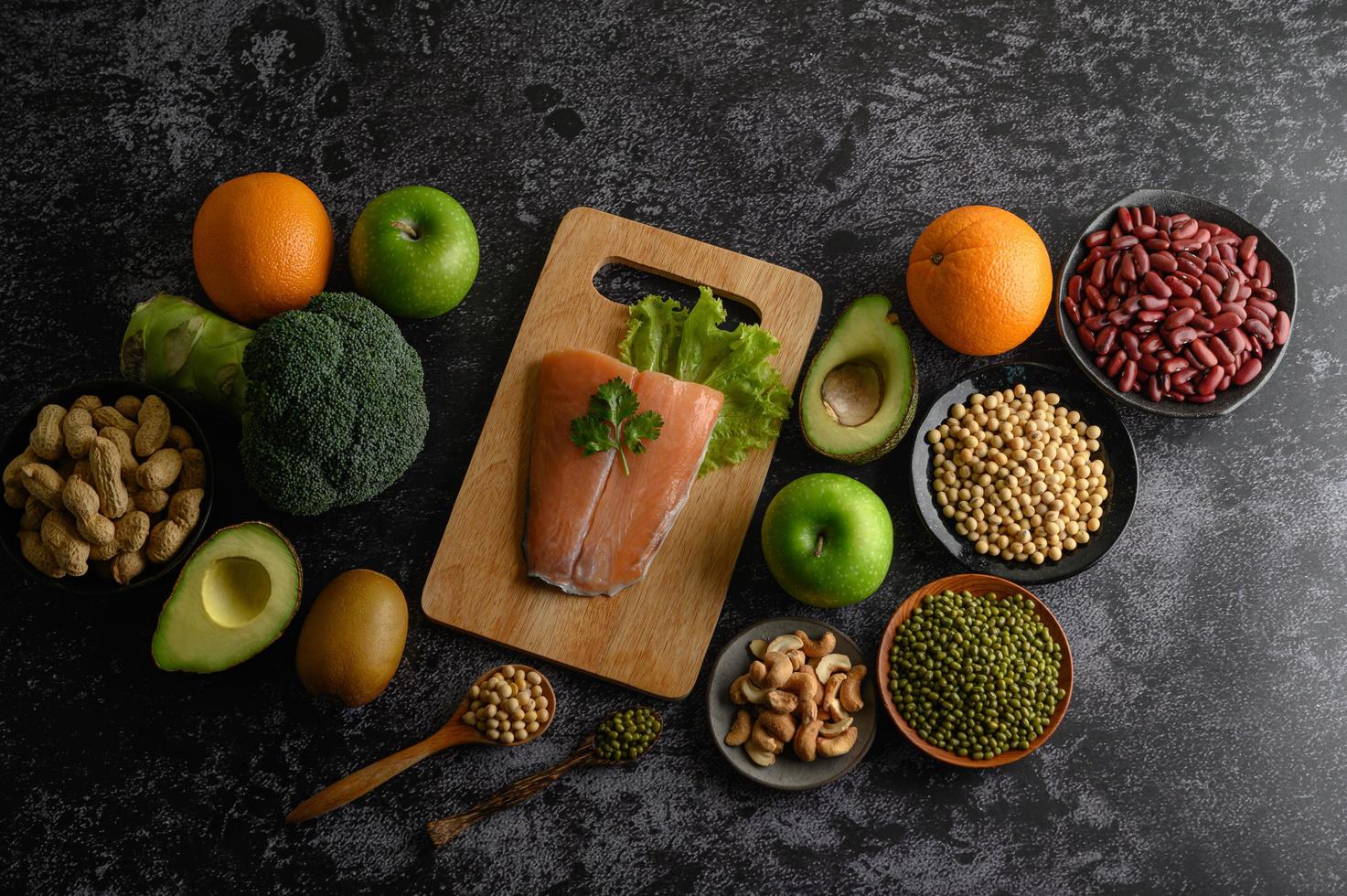 peulvruchten, fruit en zalmvissen op een houten snijplank foto