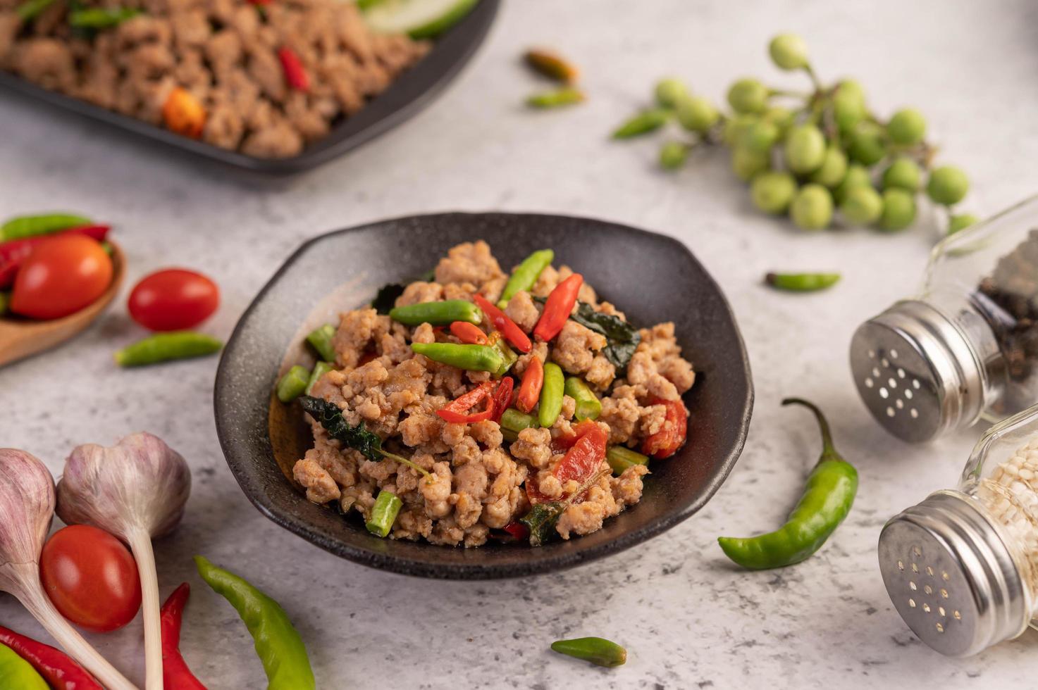 Pittige Varkensgehakt Salade Met Rijst, Chili En Tomaten Op Een Zwarte Plaat foto