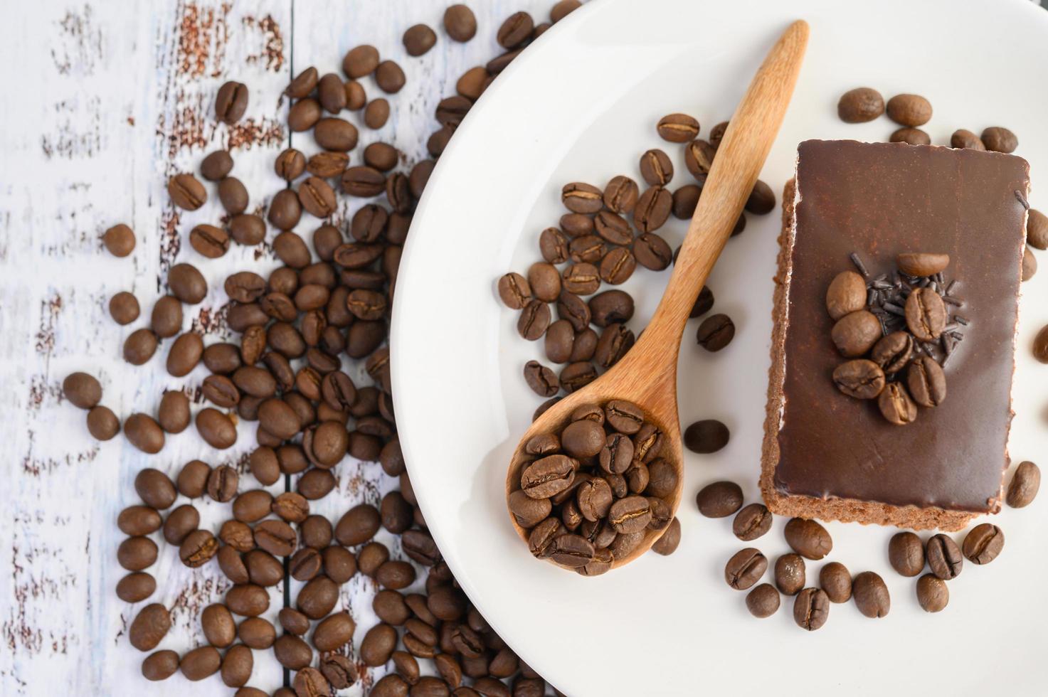 chocoladetaart op een witte plaat en koffiebonen foto