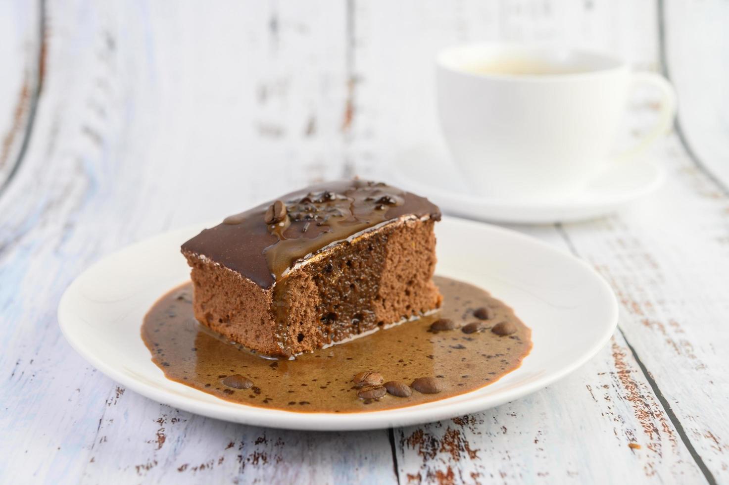 chocoladetaart gegarneerd met koffie op een witte plaat foto