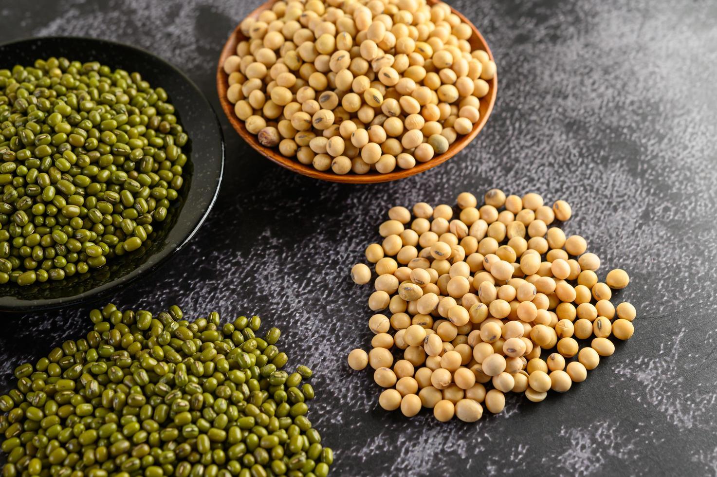 soja en groene bonen op een zwarte cementvloer achtergrond foto