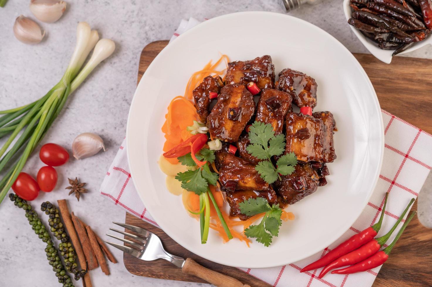 zoet varkensvlees met chili, lente-uitjes, wortelen en koriander foto