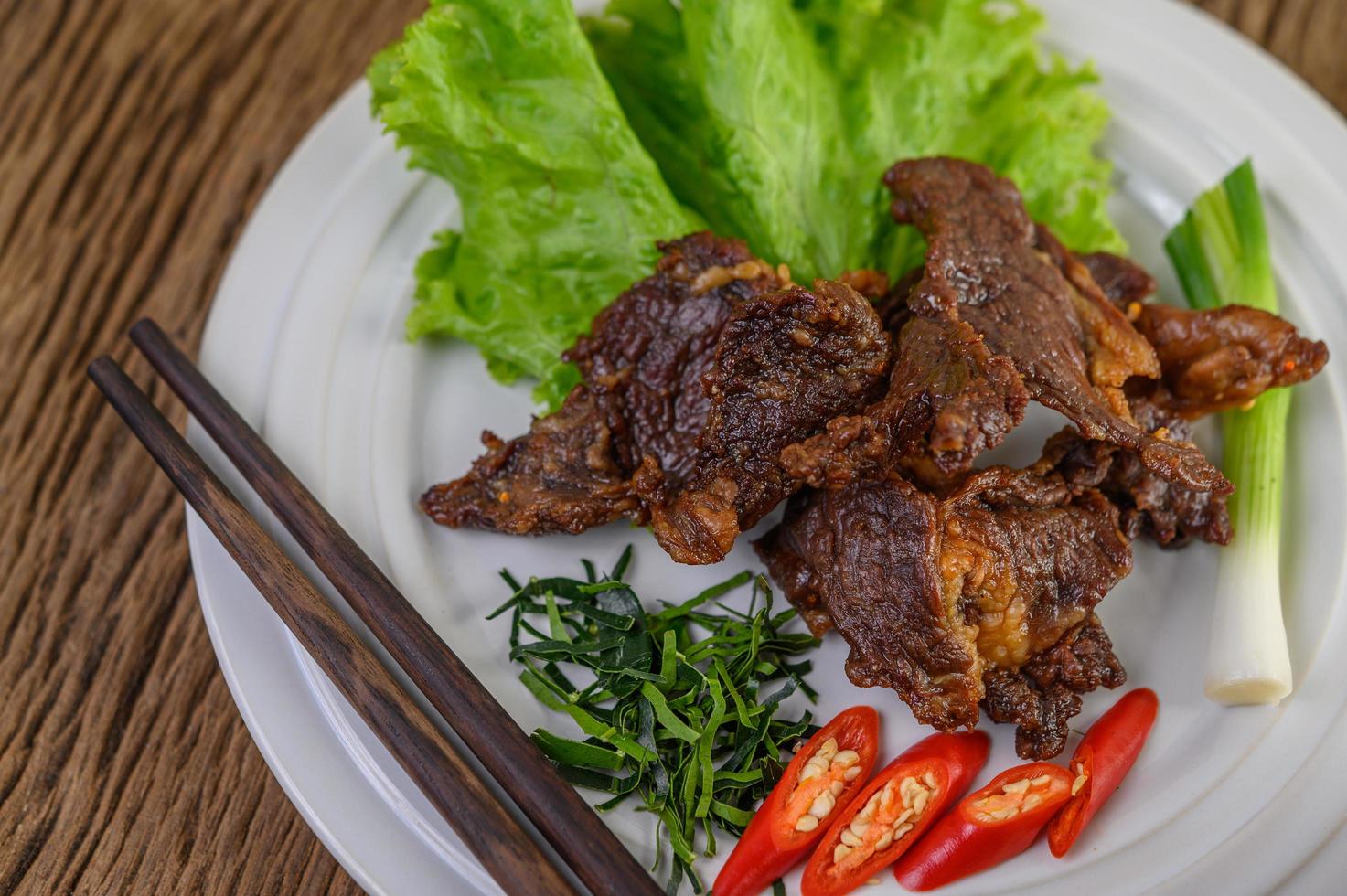 rundvlees gebakken thais eten met lente-ui, limoen, chili en salade foto