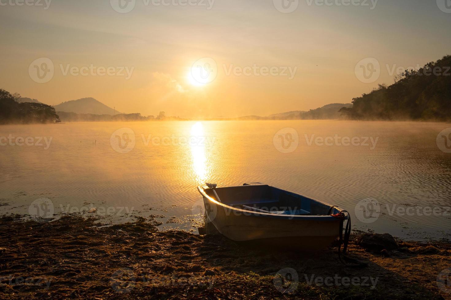 boot gemaakt van vezel hij was geparkeerd Aan de rand van een strand in de reservoir gedurende de zonsopkomst. Bij harak Woud park huai naam Mens reservoir loei Thailand 21 jan 2023 foto