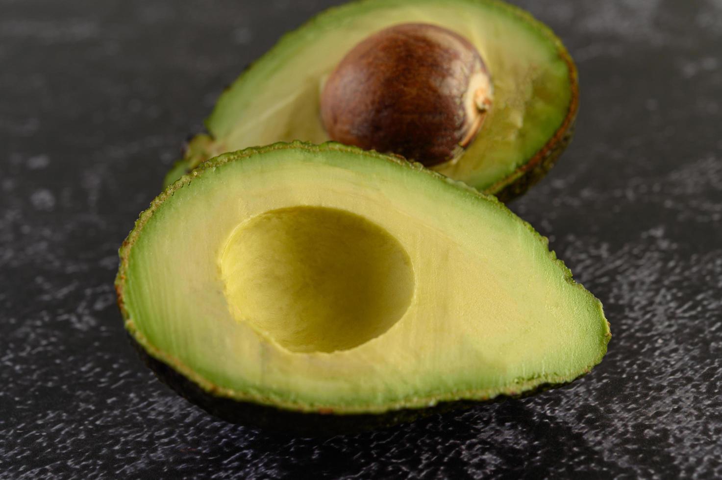 gehalveerde avocado op zwart cement foto