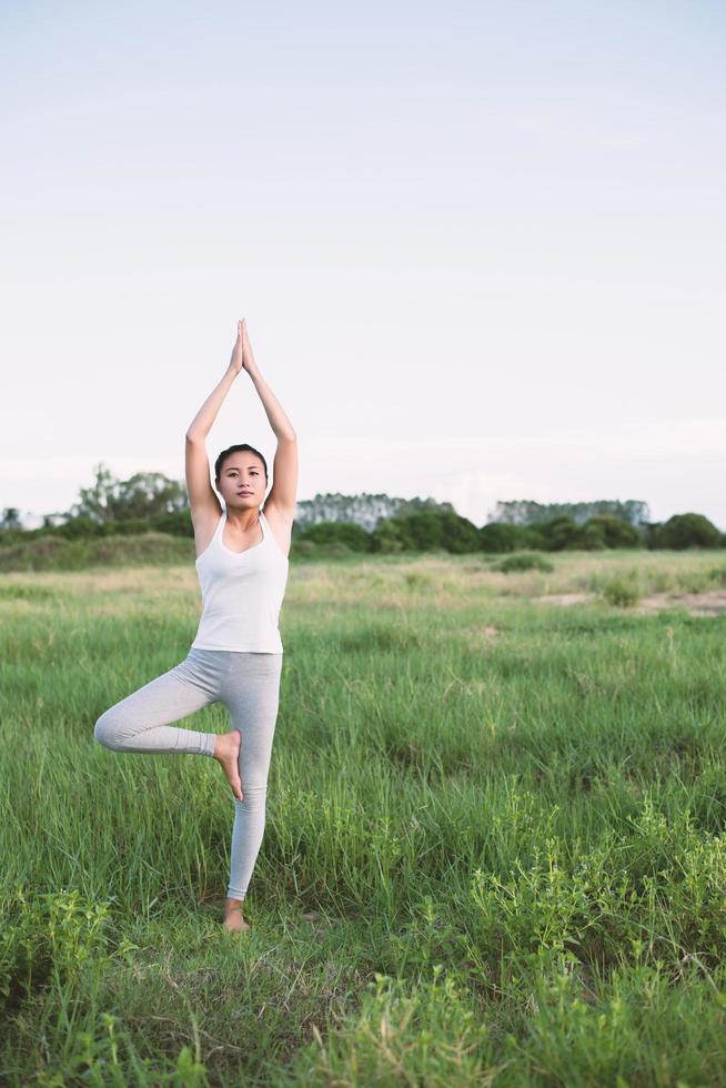 jonge mooie vrouw beoefenen van yoga in de weilanden foto