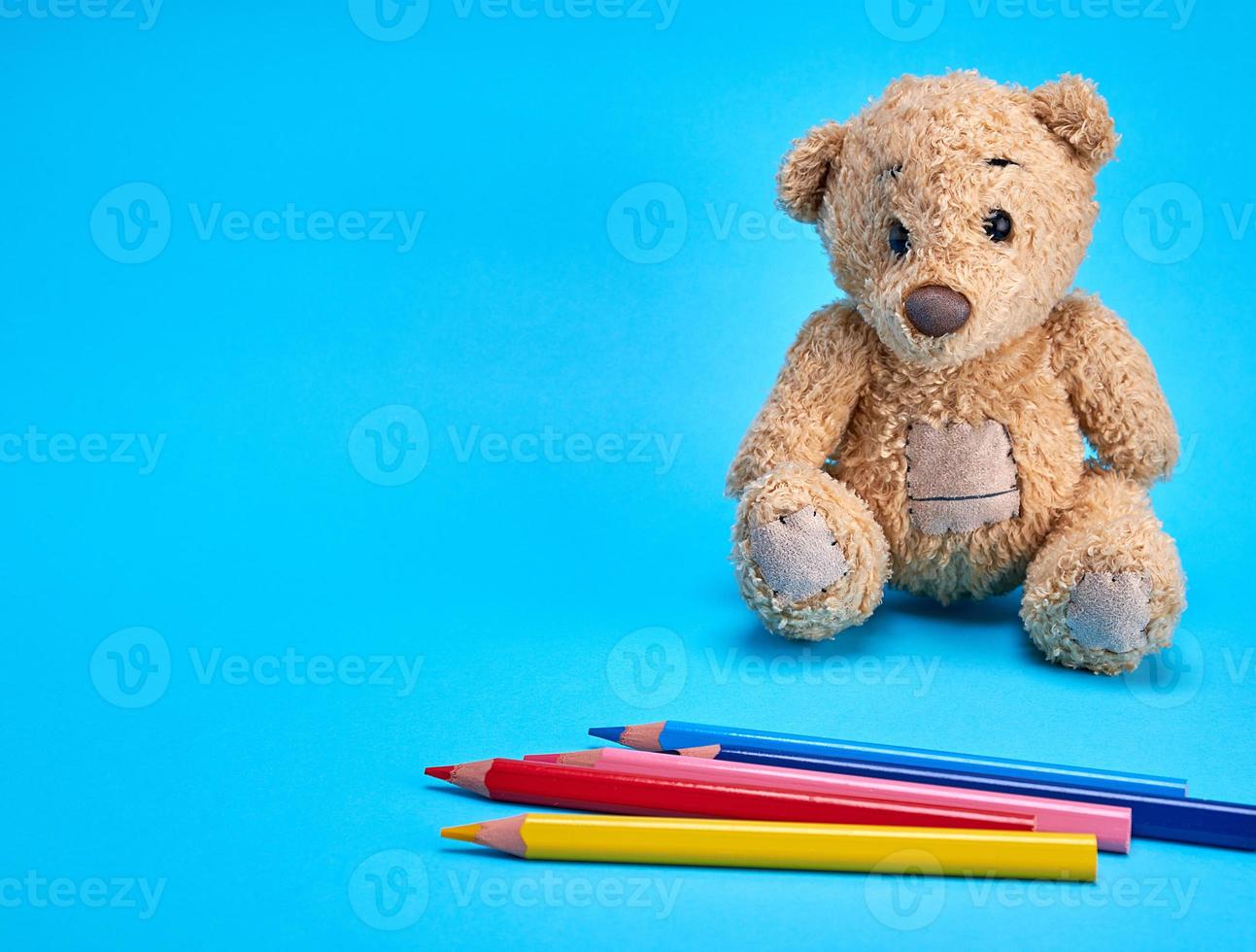 bruin teddy beer en veelkleurig houten potloden foto