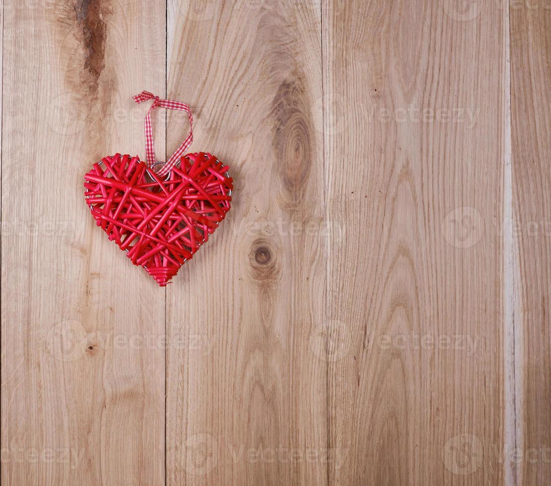 houten achtergrond van eik borden en een rood rieten hart foto