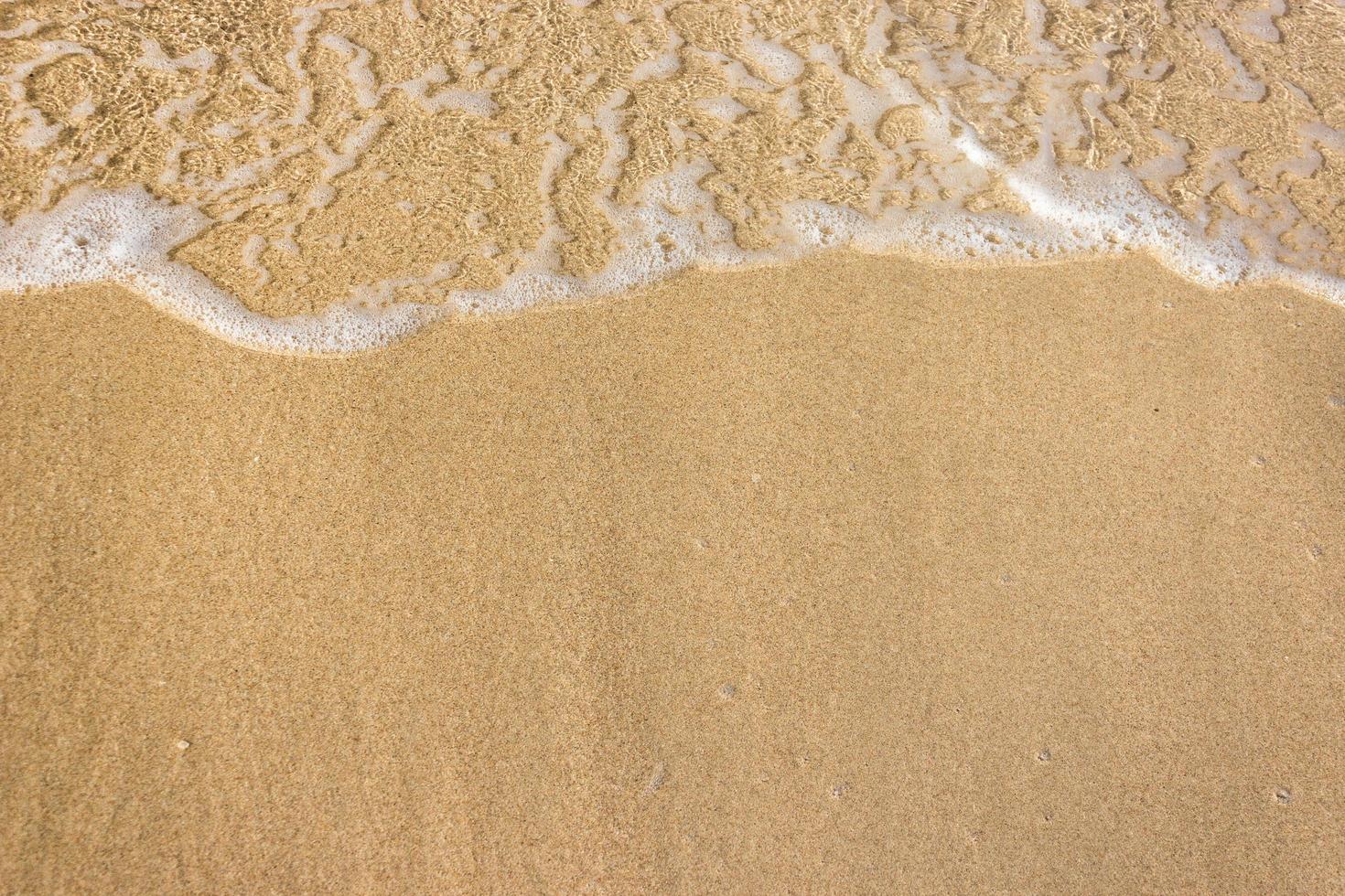 oceaangolven op zandstrand foto