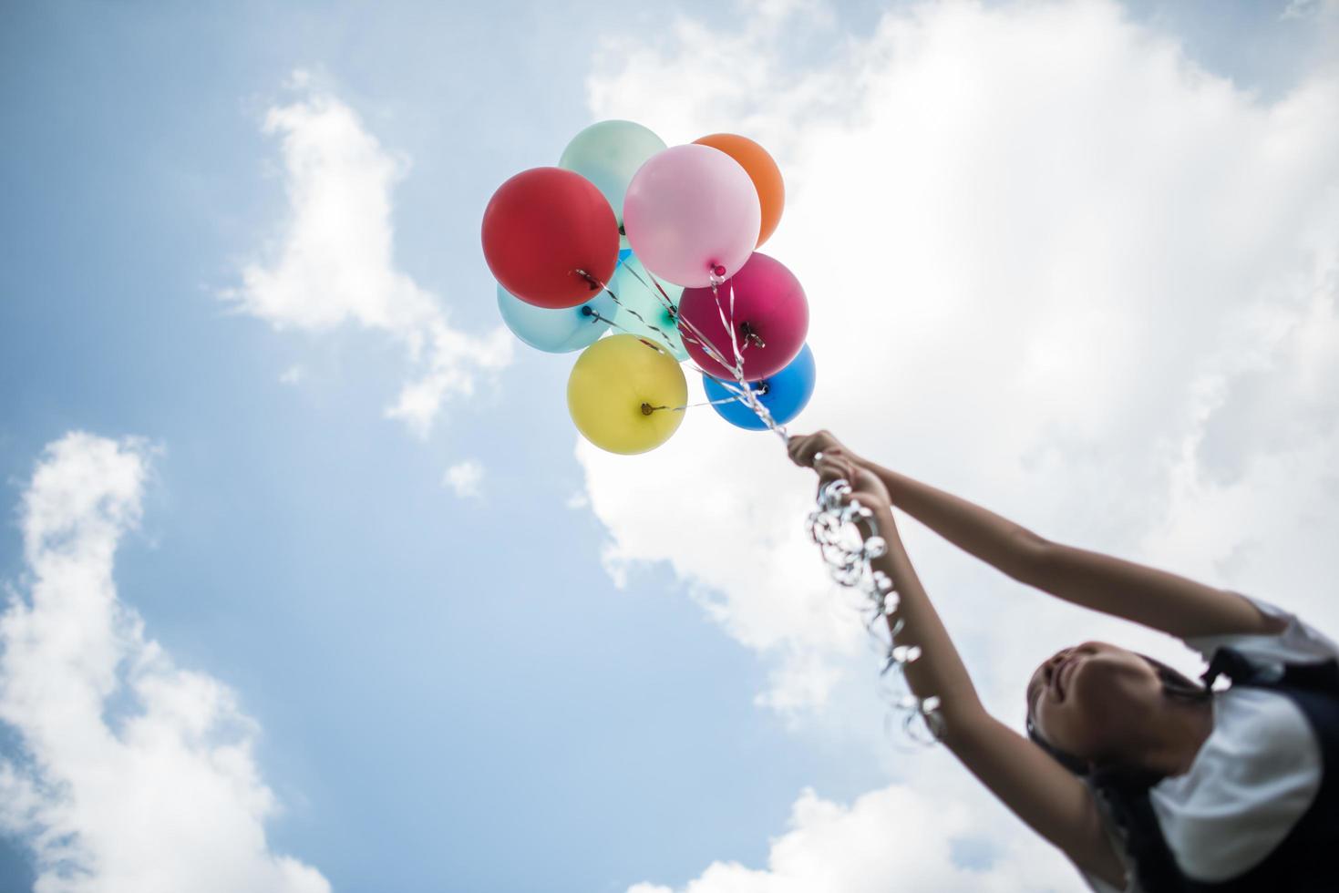 jong meisje met kleurrijke ballonnen in de natuur foto