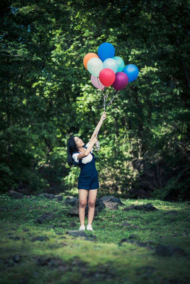 jong meisje met kleurrijke ballonnen in de natuur foto