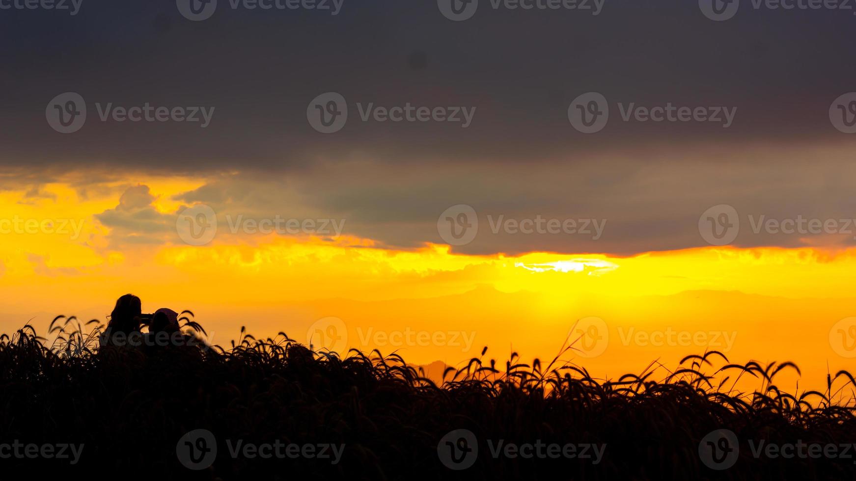 zonsopkomst in de landschap van heuvels en weiden. mensen Gaan omhoog de bergen naar zien de landschap, de zon, de ochtendgloren, en de horizon bovenstaand de grond foto