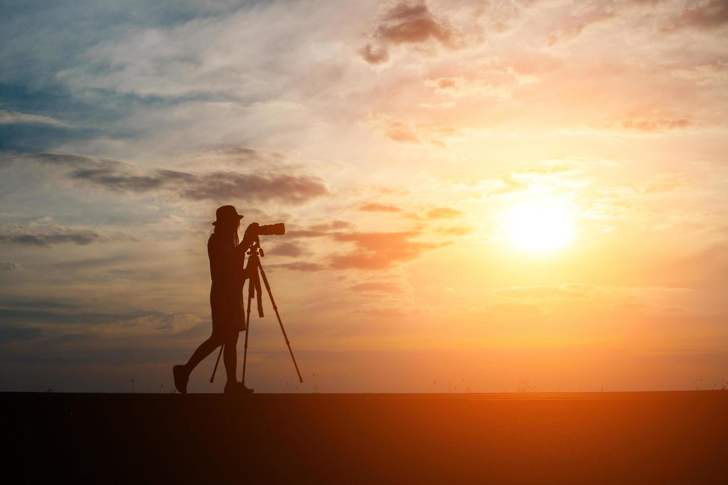 silhouet van een fotograaf fotograferen bij zonsondergang foto