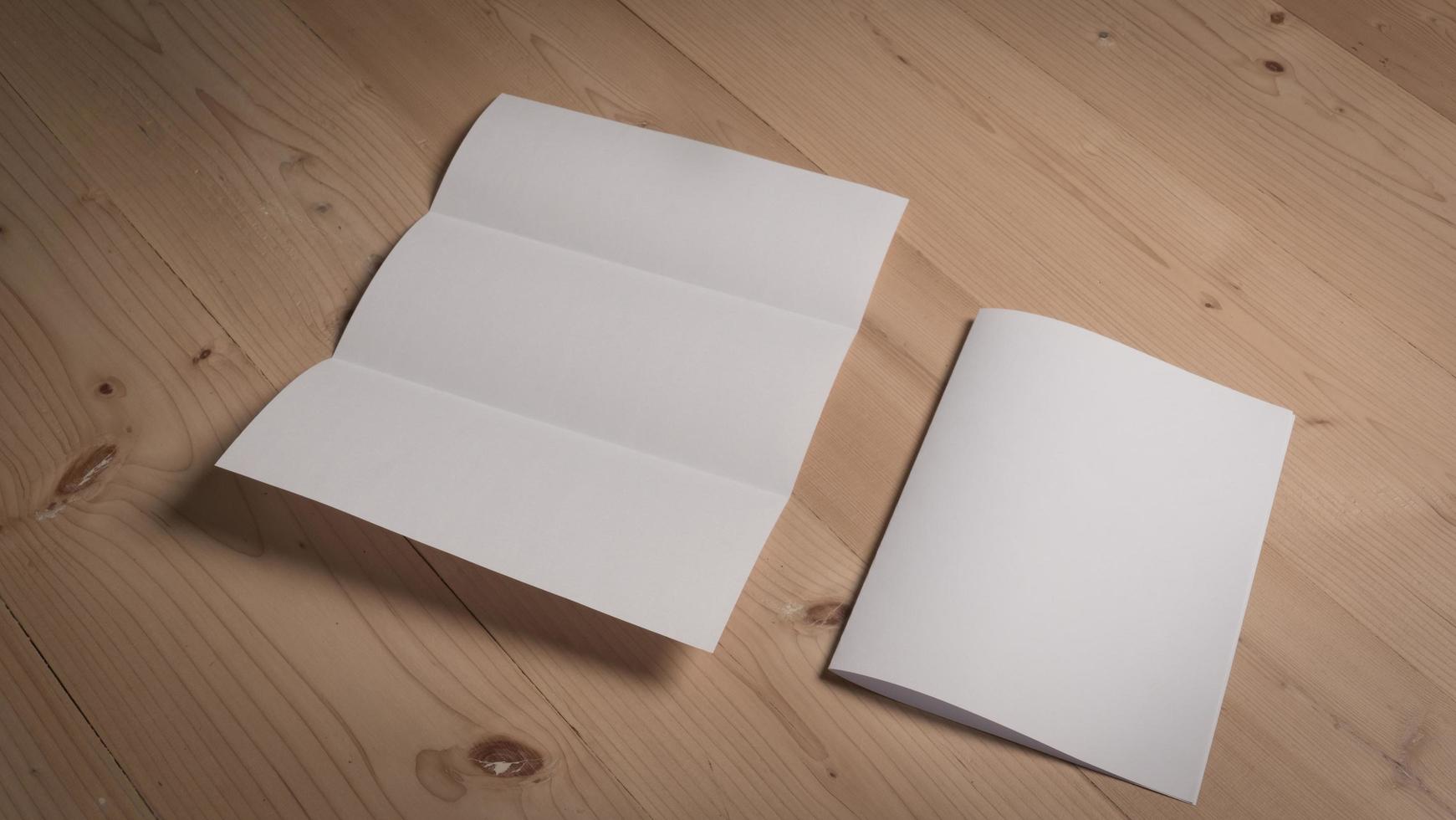 wit blanco gevouwen papier op houten tafel foto