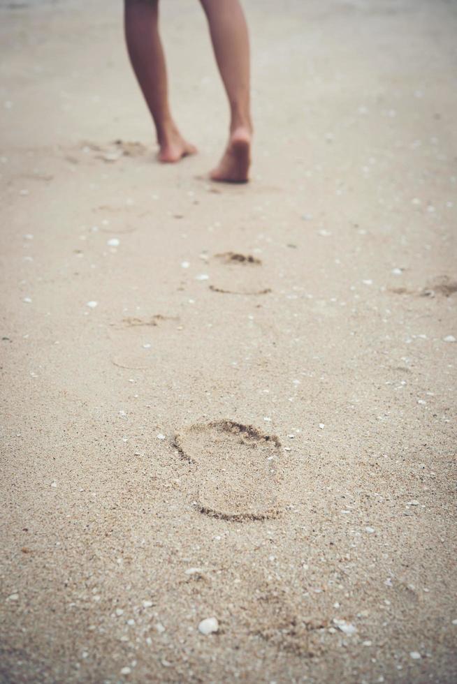 jonge vrouw stond op het strand met blote voeten foto