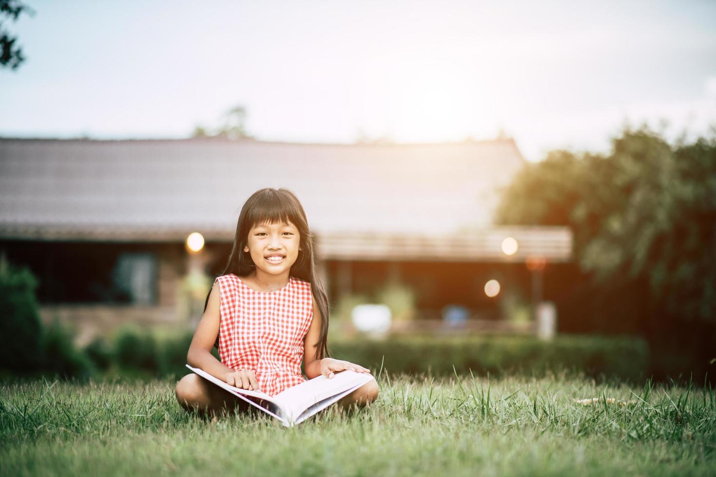 meisje dat een boek in haar huistuin buiten leest foto