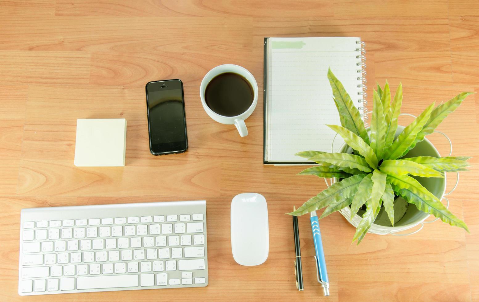 plat bureau met plant, koffie en telefoon foto