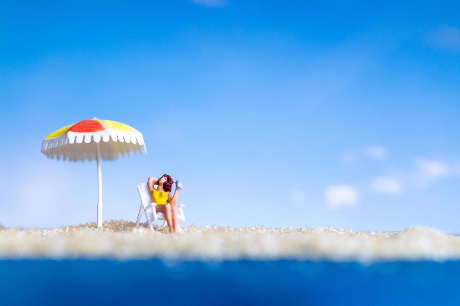 miniatuurbeeldje persoon zonnebaden op het strand foto