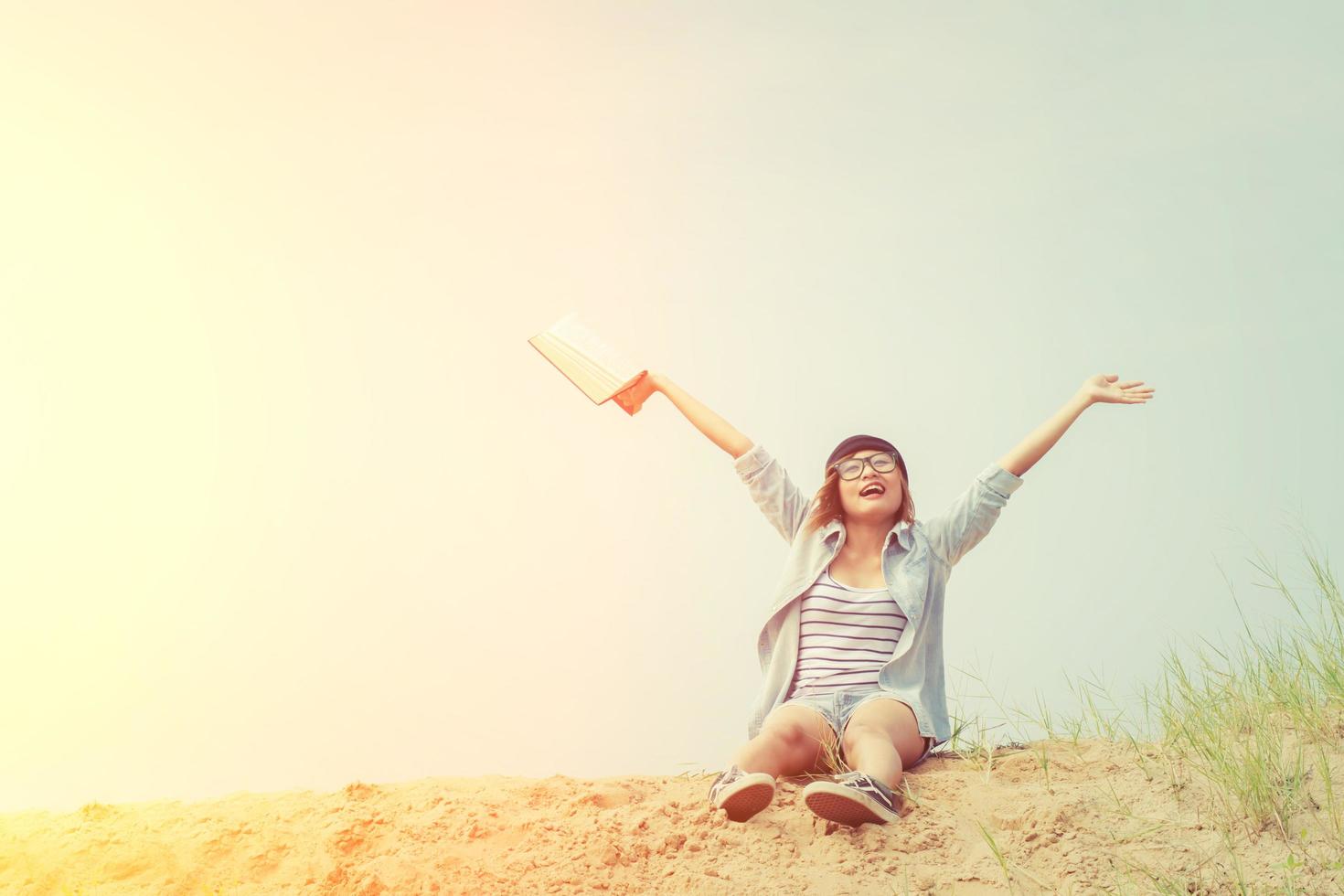 mooie jonge vrouw die een boek leest op het strand foto