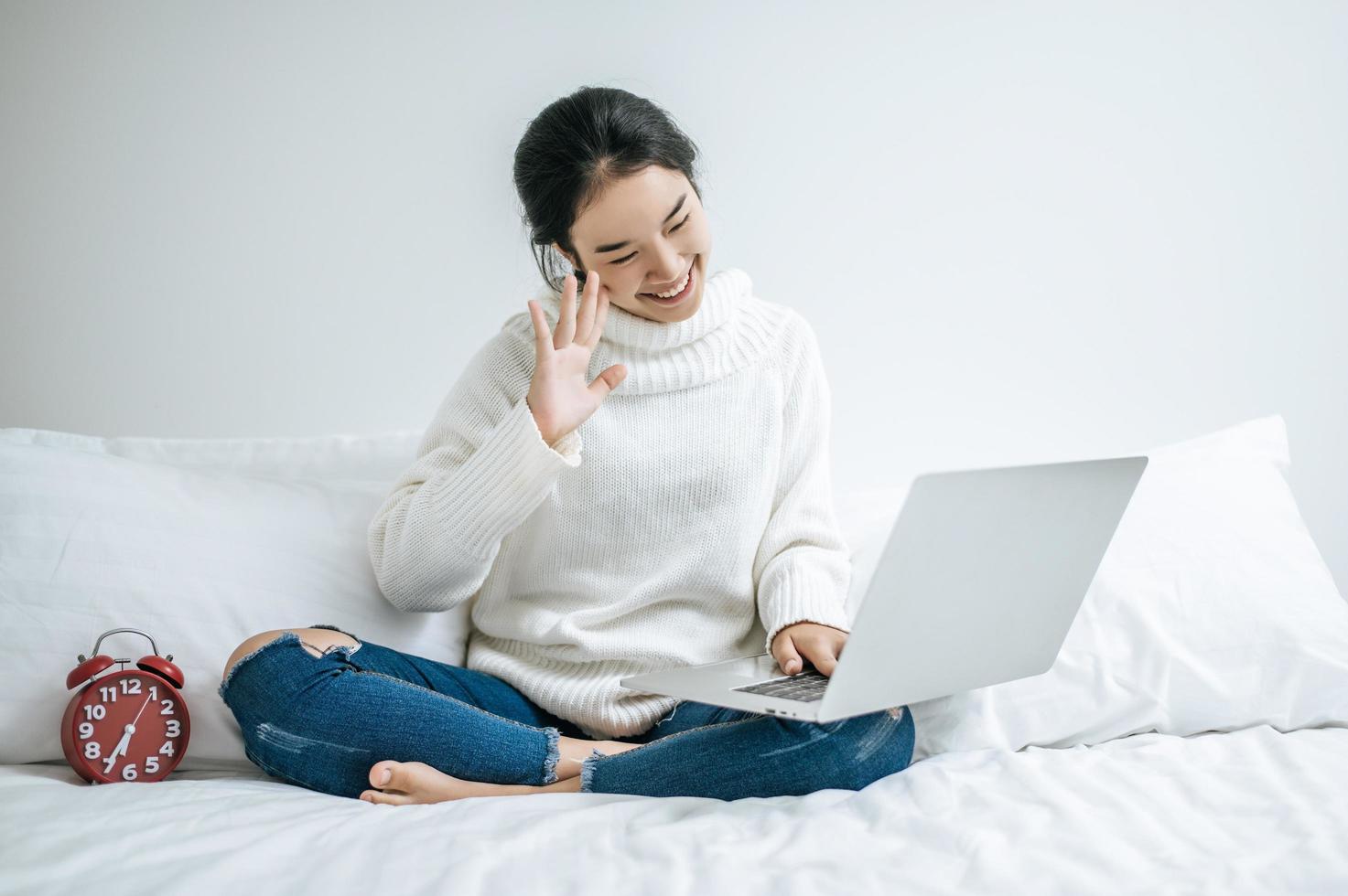 jonge vrouw die een wit overhemd draagt dat op haar laptop speelt foto