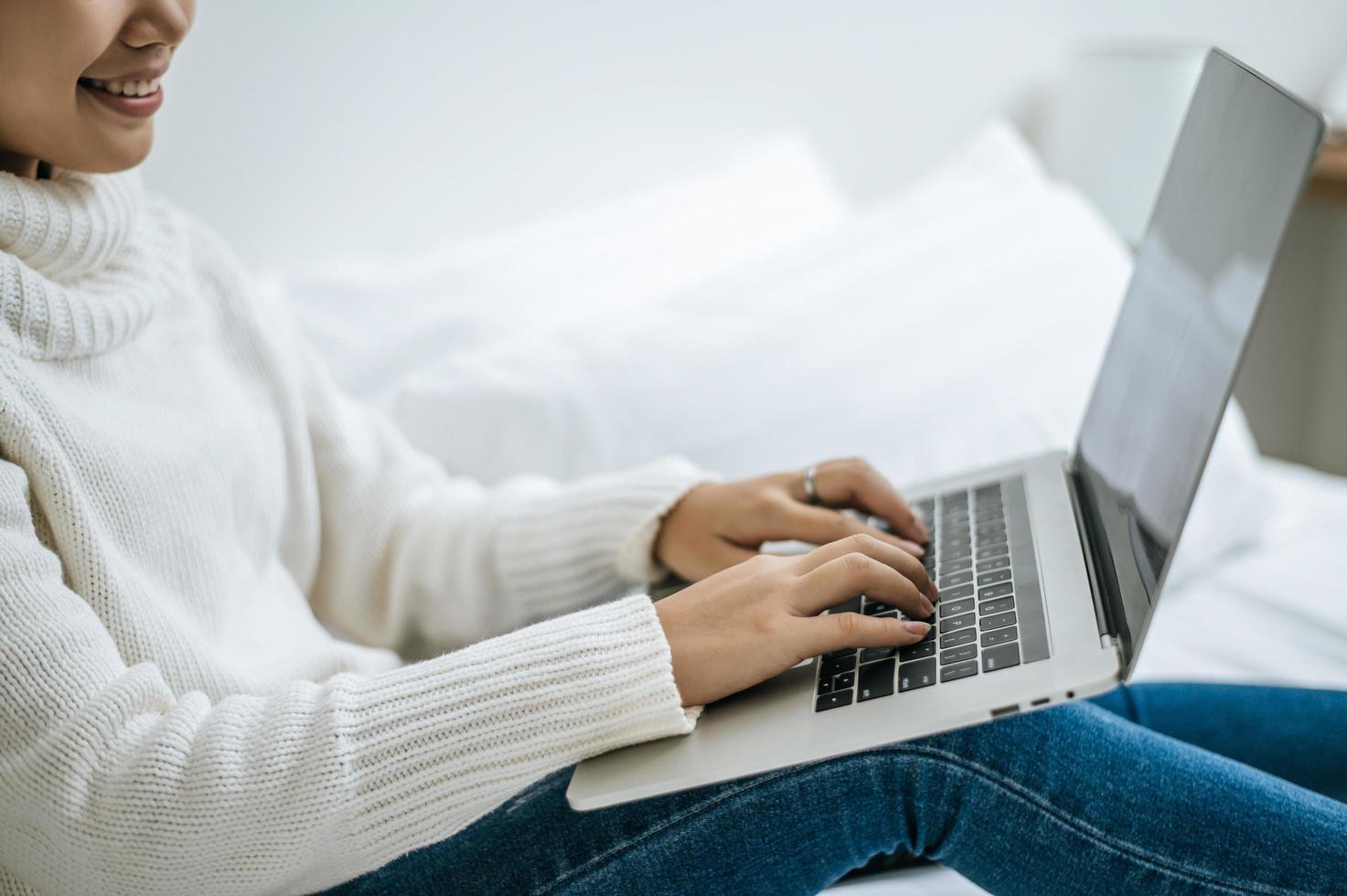 een jonge vrouw die graag op haar laptop speelt foto