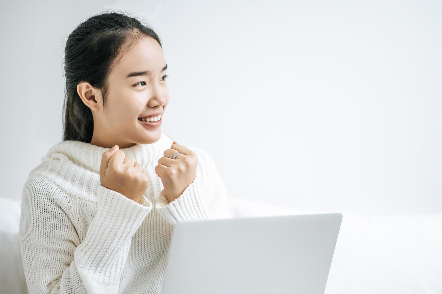 jonge vrouw die een wit overhemd draagt dat op haar laptop speelt foto