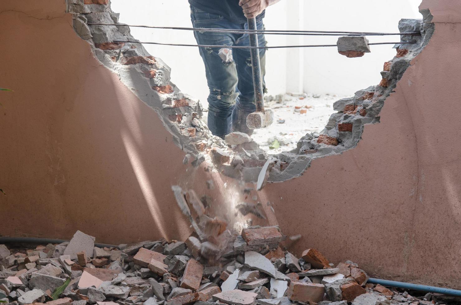 man die de muren van een huis sloopt foto