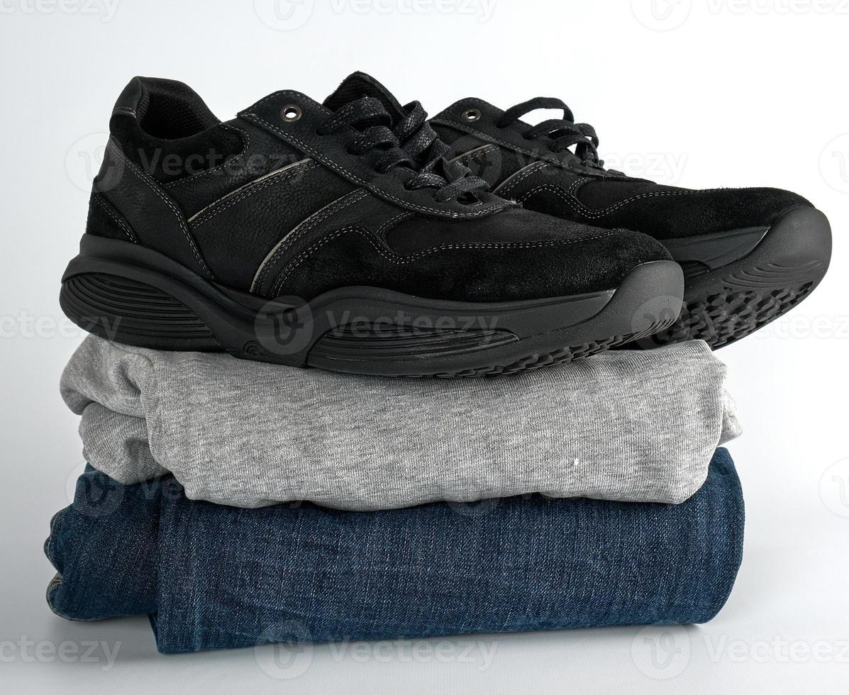 stack van kleren jeans, trui en zwart paar- van Mannen schoenen foto