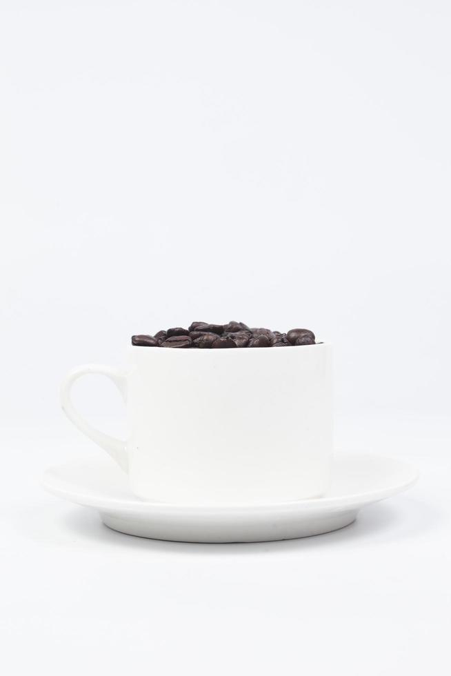 beker met koffiebonen op witte achtergrond foto