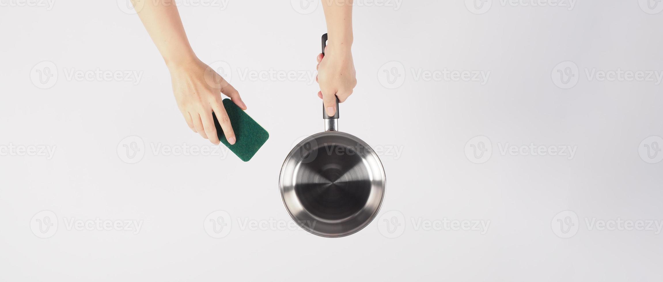 pot schoonmaak Mens hand- Aan wit achtergrond schoonmaak de niet stok pot met handig schotel het wassen spons welke geel kleur Aan de zacht kant en groen Aan moeilijk kant voor hygiëne na koken. elektrisch pot foto