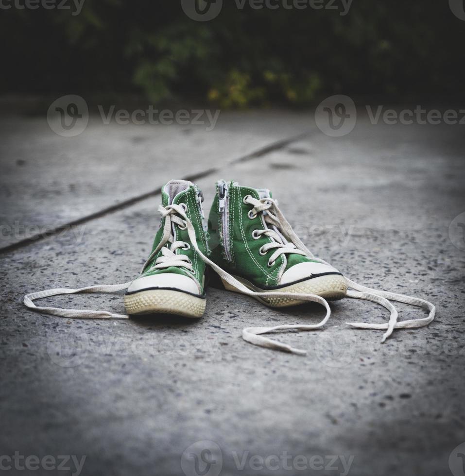 oud textiel kinderen groen klassiek sportschoenen met losgemaakt veters foto
