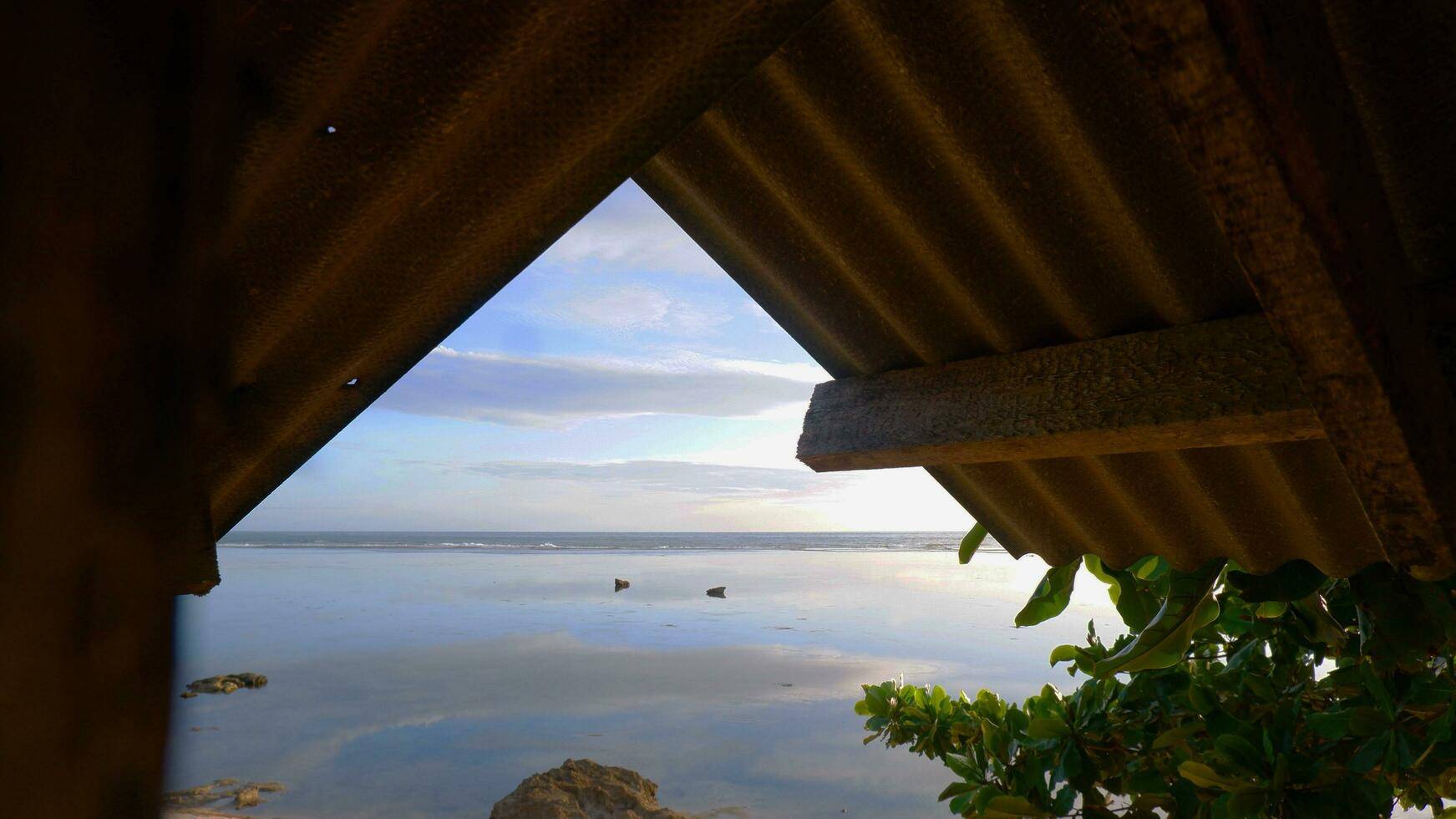 mooi visie van de strand van binnen een houten huis of Prieel foto