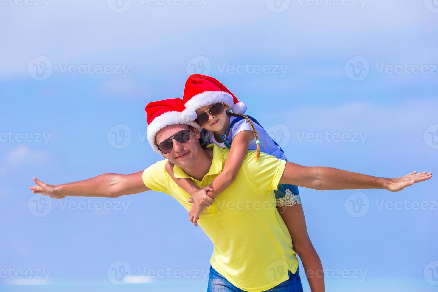 weinig meisje en gelukkig vader in de kerstman hoeden genieten Kerstmis vakantie foto