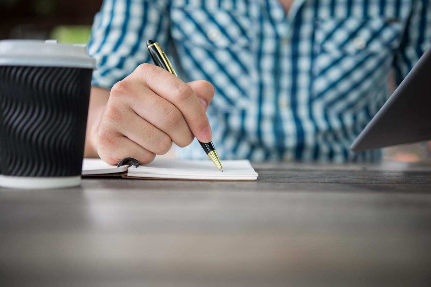 close-up van hand schrijven in notitieblok met pen foto