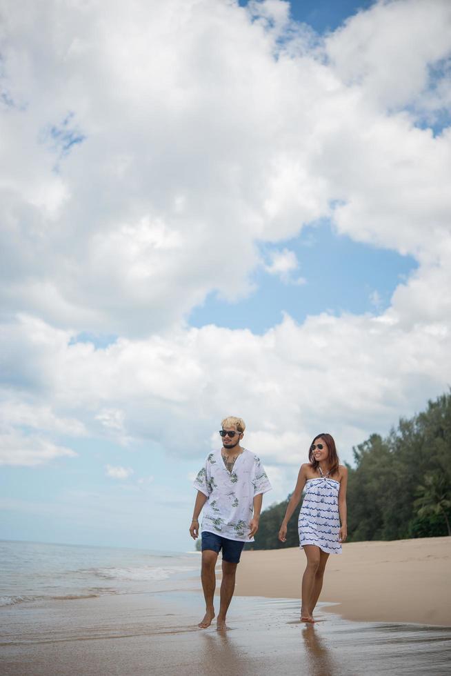 jonge gelukkige paar wandelen op het strand foto