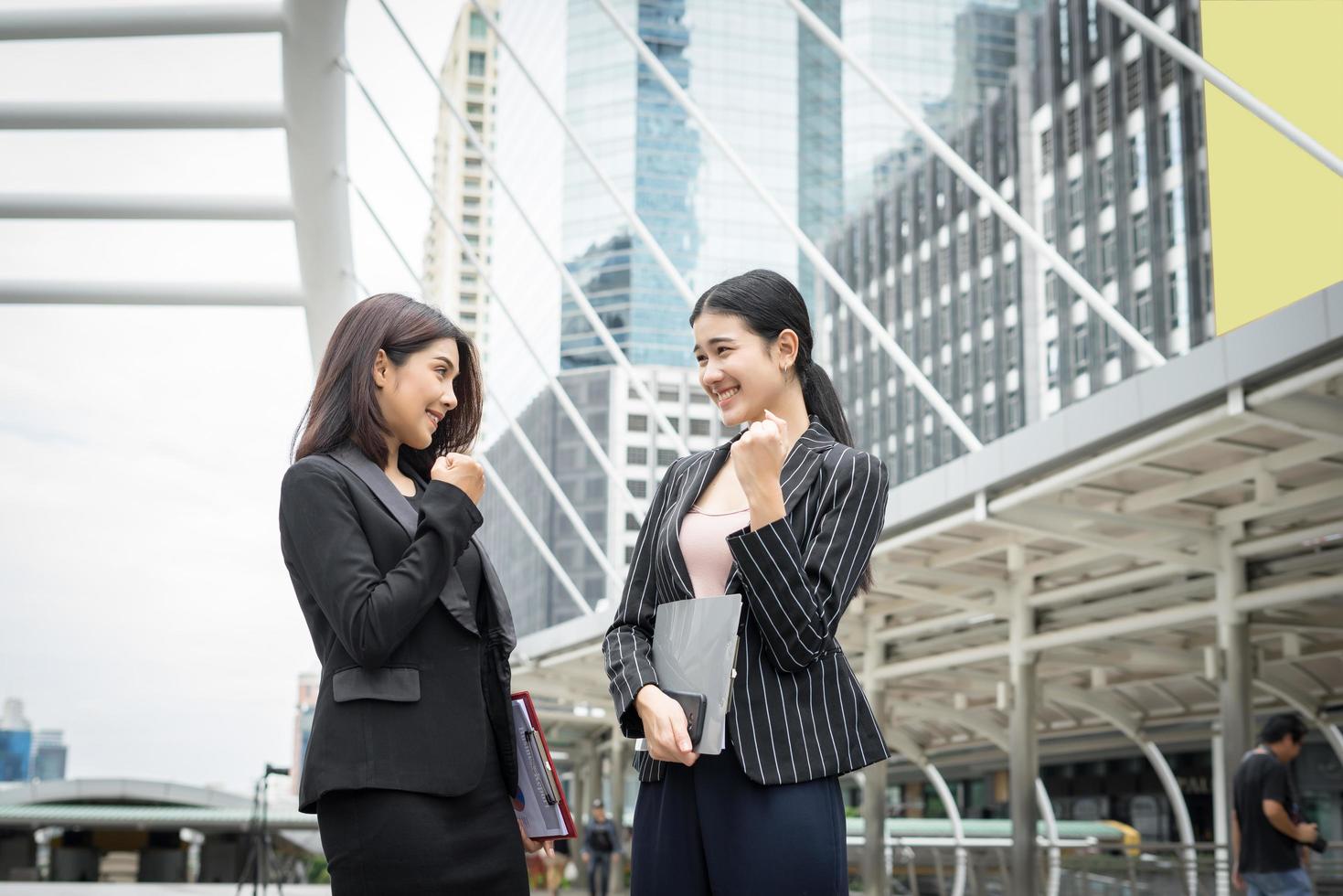 twee zakenvrouwen staan en bespreken hun werk voor het kantoor foto