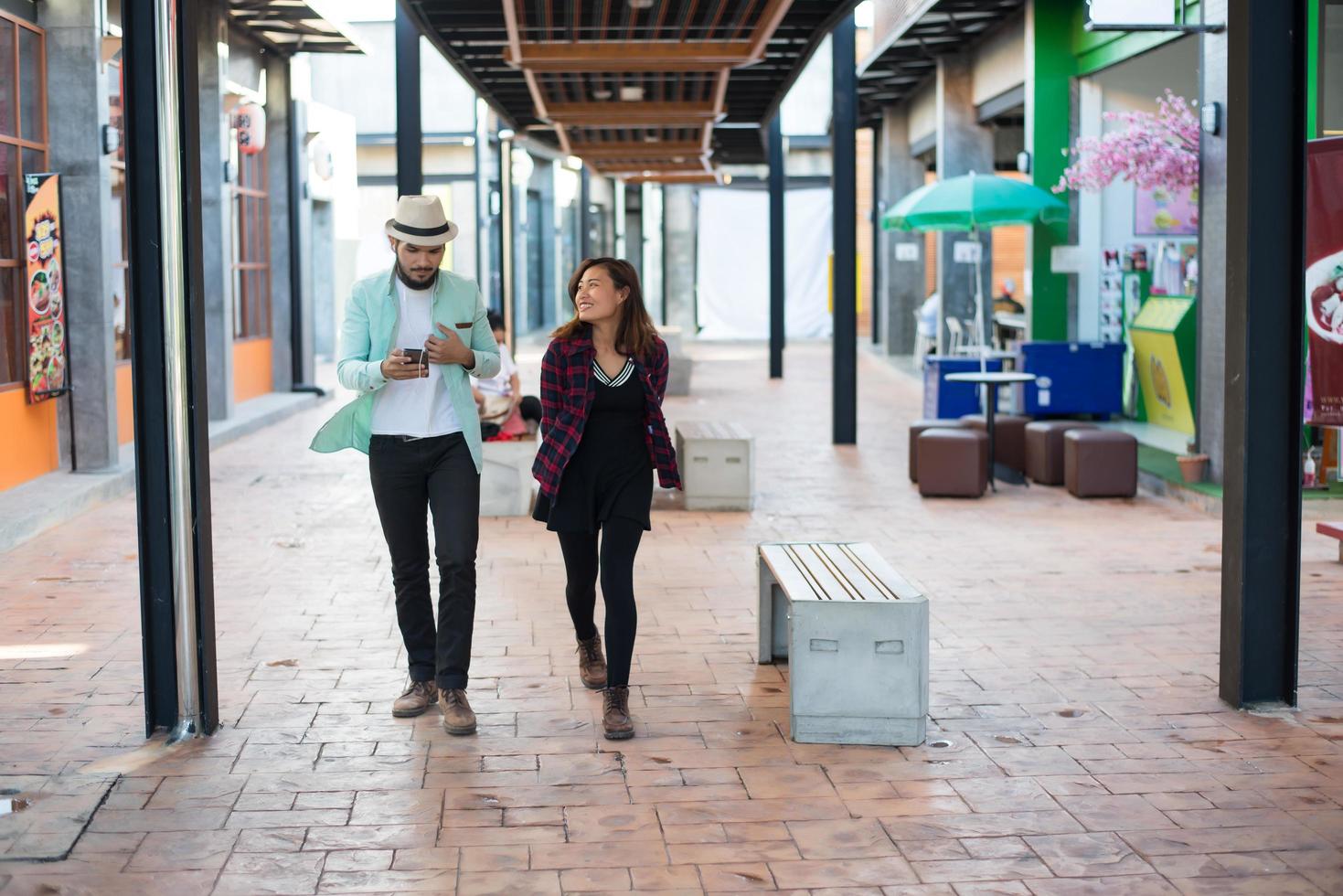 jong koppel lopen samen op stedelijke straat foto