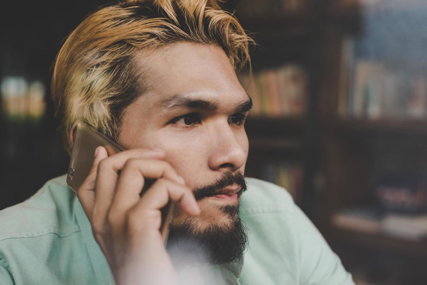 zakenman hipster praten over smartphone in café-bar foto