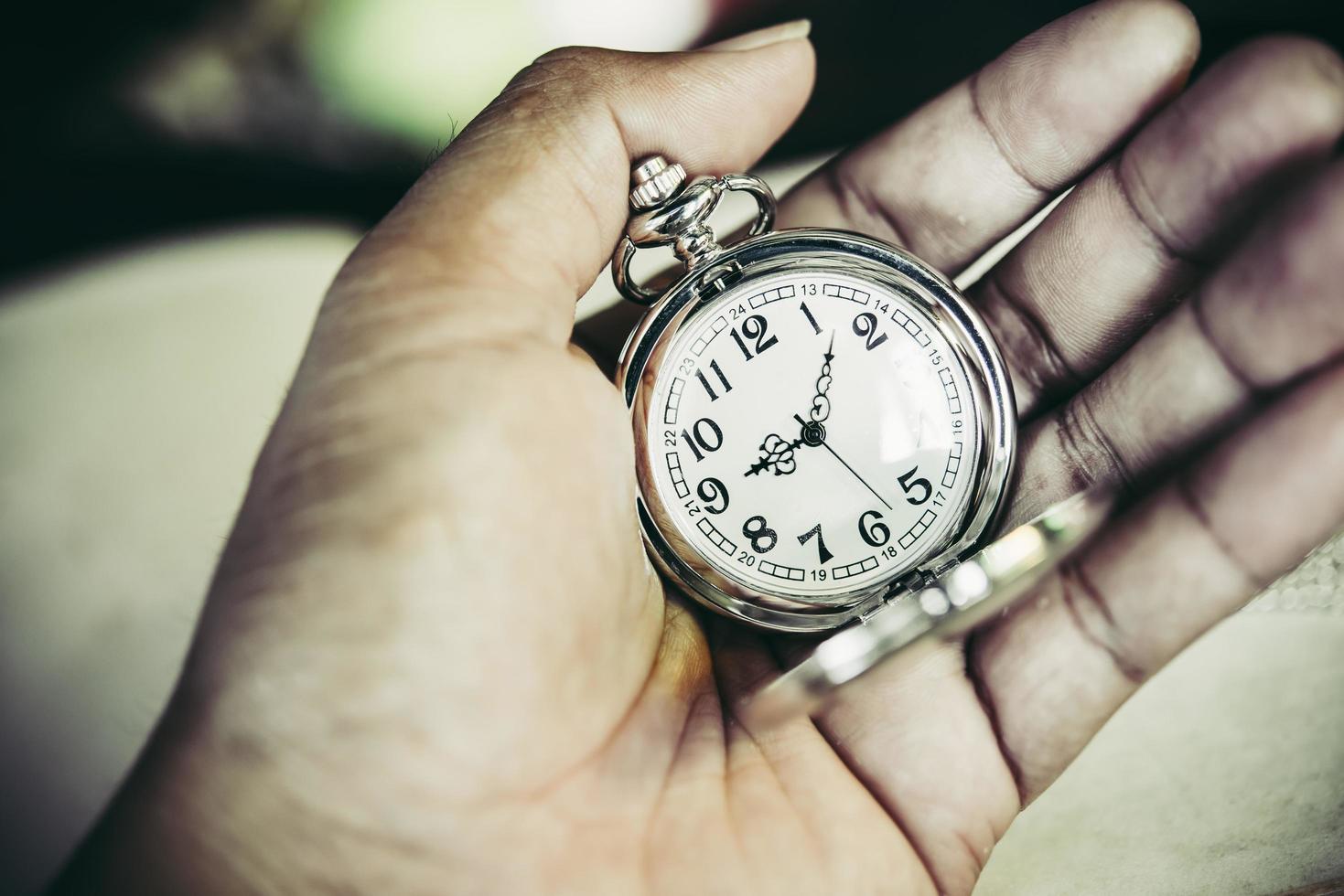 close-up van iemands hand met een vintage zakhorloge foto